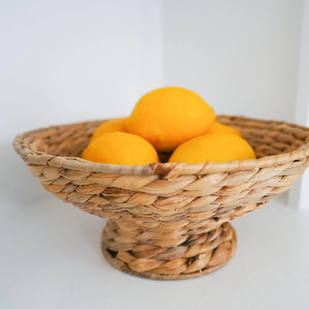 rattan bowl basket, large wicker bowl, rattan decorative bowl, small rattan bowl, large woven bowl, round pedestal bowl, round decorative bowl, what to put in a pedestal bowl, wicker furniture, Wicker Pedestal Bowl, fruit bowl, boho home decor, boho fruit bowl, kitchen accessories, home decor store near me, online home decor store, woven bowl, soft bowls, kitchen decor, calla collective home, calla home